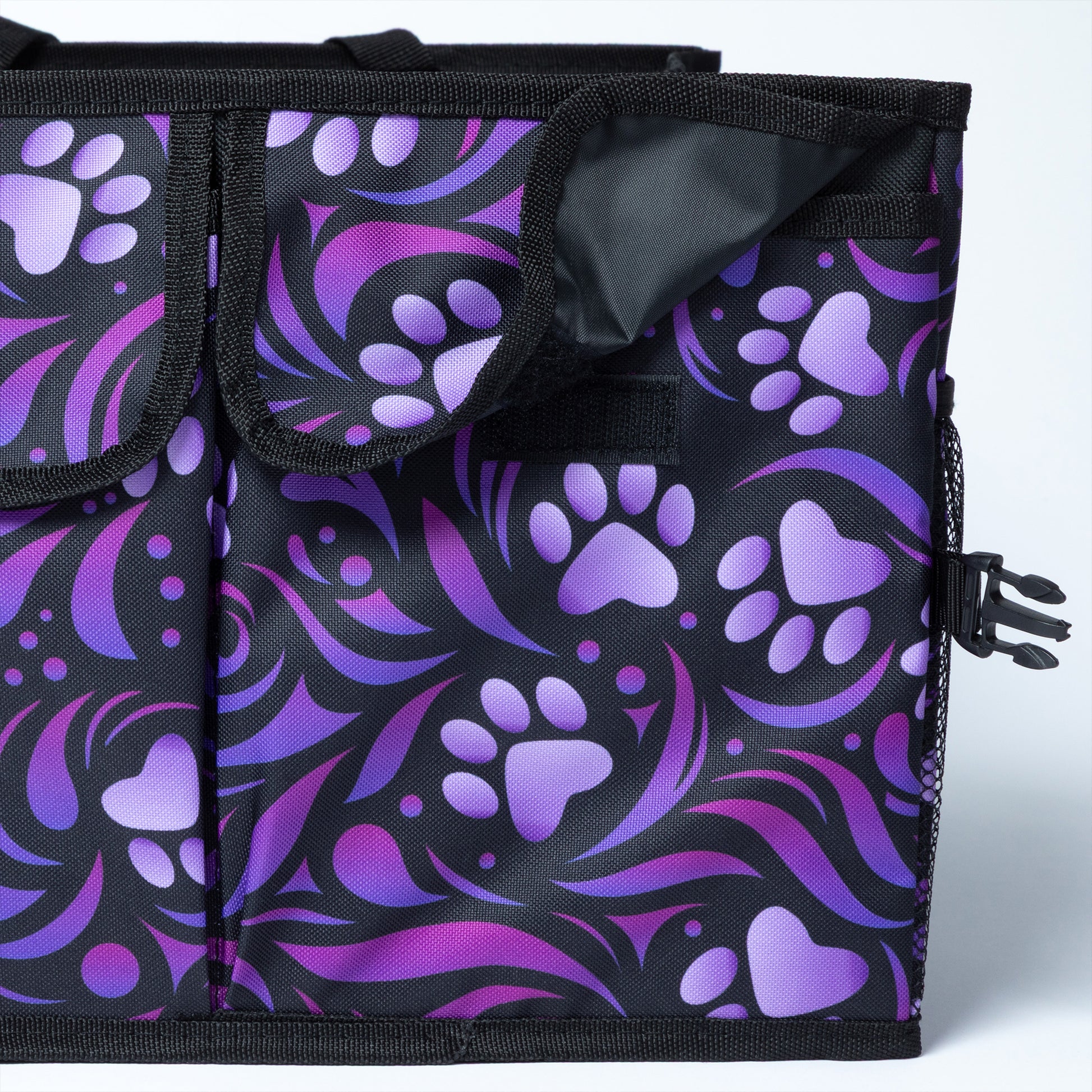 Close up of a flap closure pocket on the side of a collapsible car trunk organizer, featuring a purple paw print design.