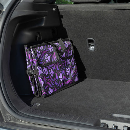 A purple paw print patterned car trunk organizer folded flat, in a car trunk.
