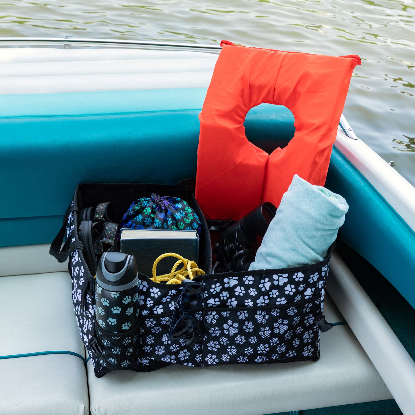 Many compartment organizer with items including a life jacket on a boat.