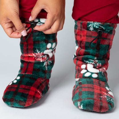 Red and green plaid slipper booties with paw prints and snowflakes, with adjustable toggles on top, against a white background.
