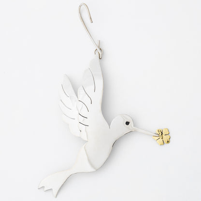 Silver tone dove ornament with gold olive branch on a white background