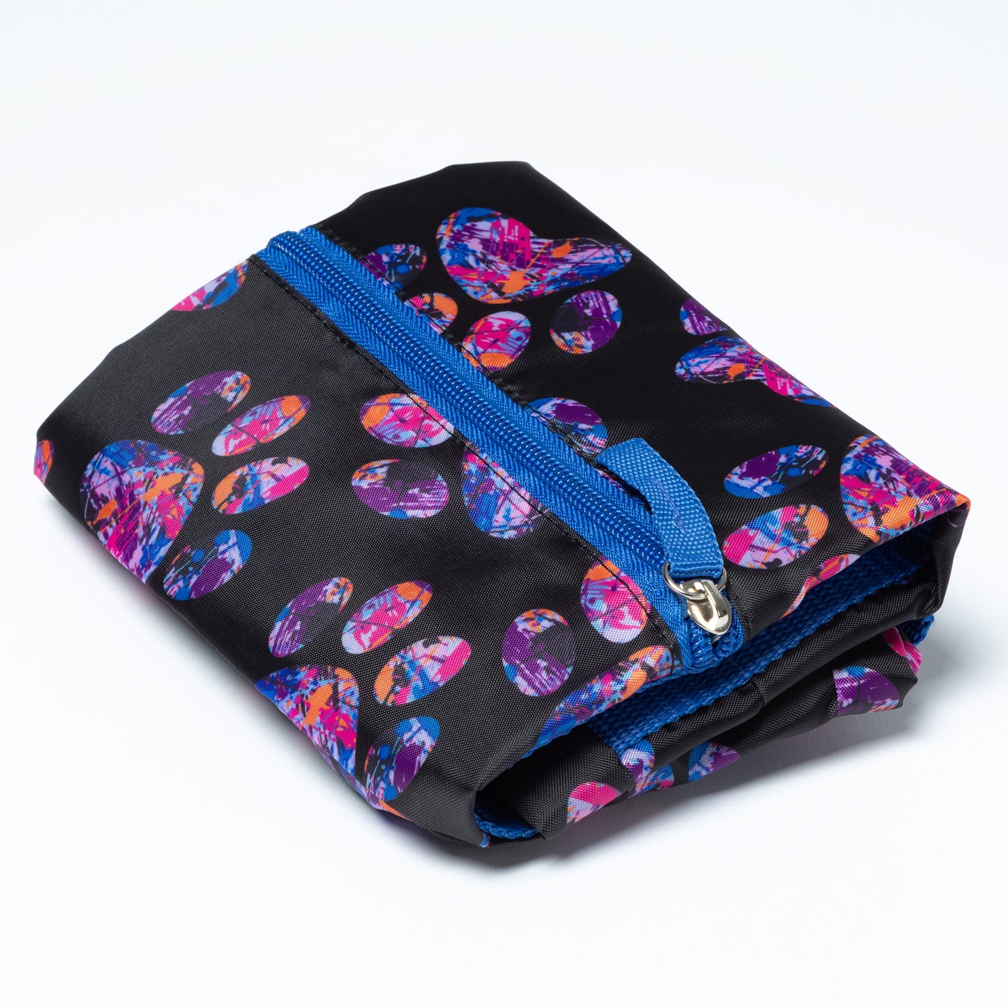 A folded black duffel bag patterned with artsy designed paw prints and a plain blue zipper on a white background.