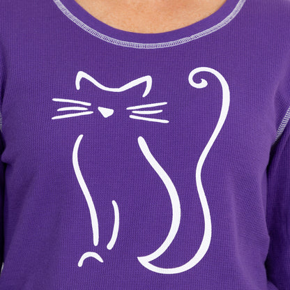 Purple shirt featuring a playful white cat graphic on the front.