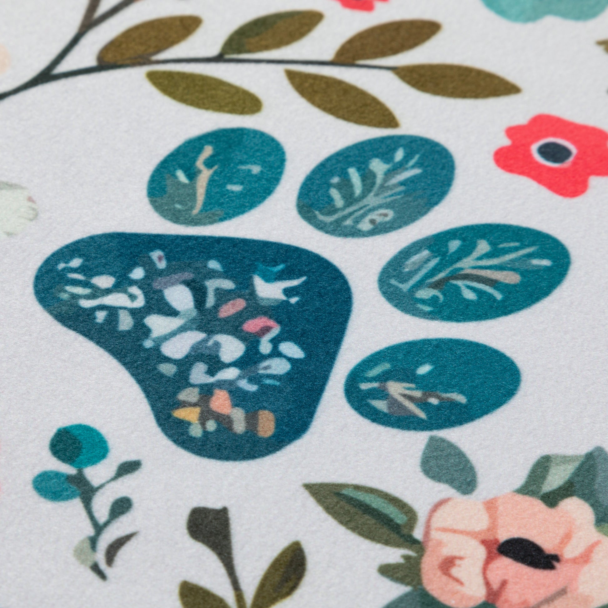 Close-up of a floral pattern paw print with blue leaves and flowers on a white background