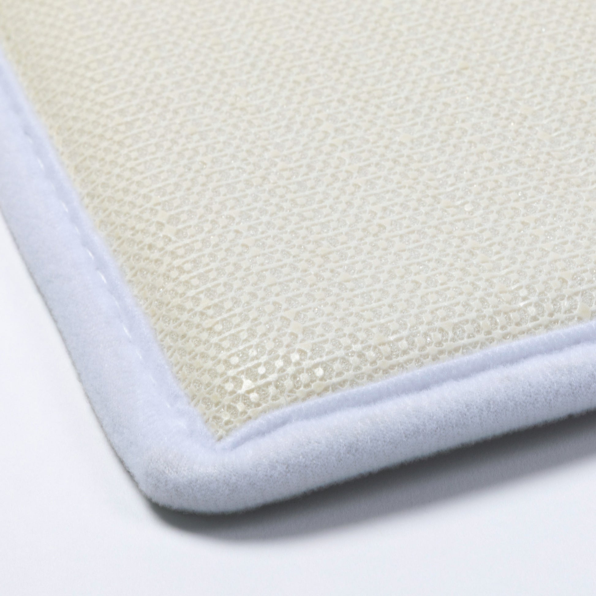 Close-up of non-slip backing textured mat with a white border on a light gray background