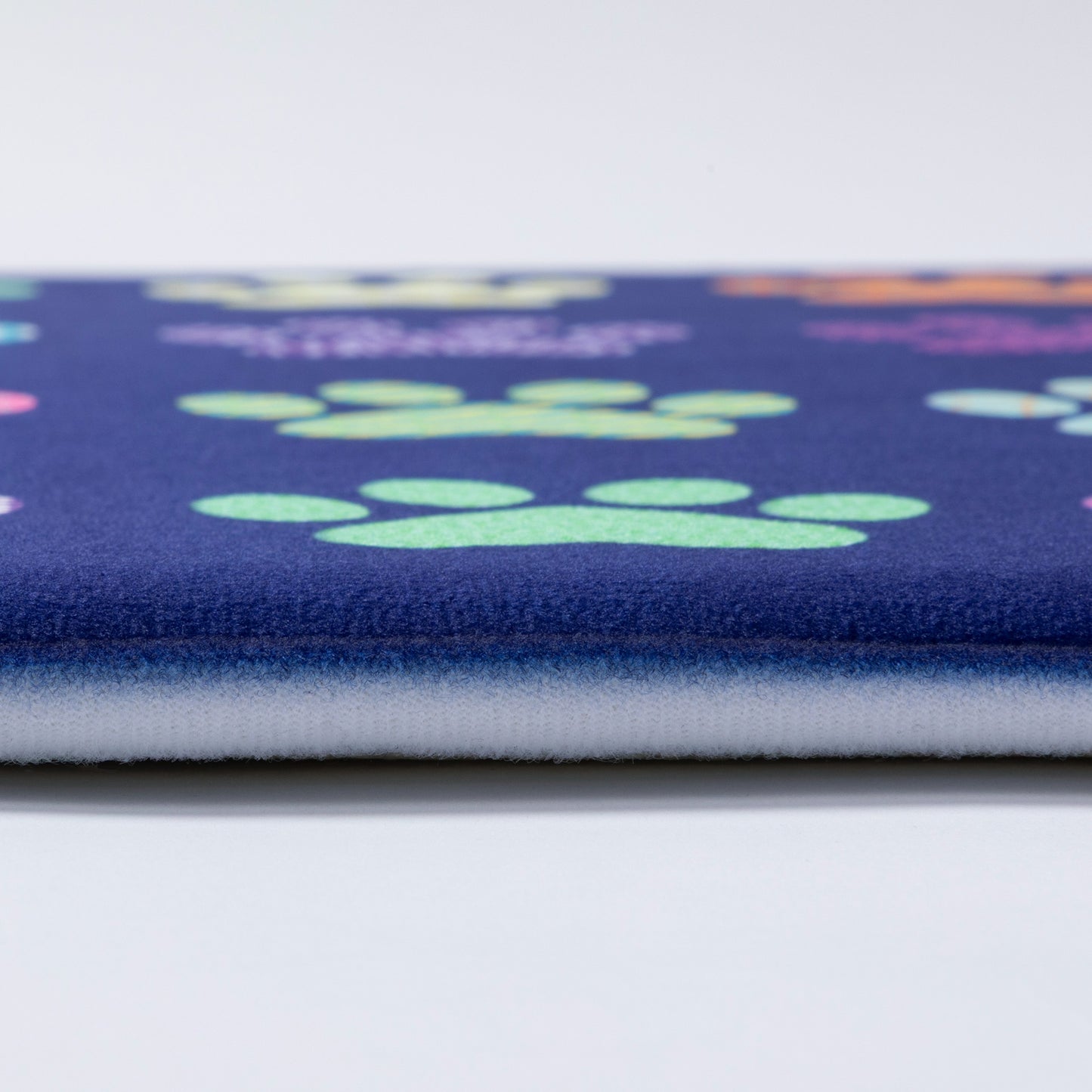 Close up of a floor mat with paw print pattern on a blue background