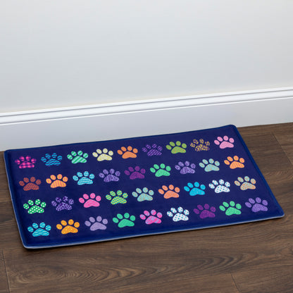 Colorful paw print mat on a wooden floor with a white wall background