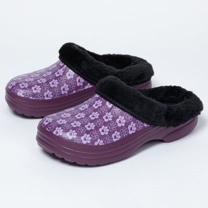 A pair of women's clog-style slippers in purple with a light paw print pattern, featuring a black faux-fur trim around the opening, shown on a light gray background.
