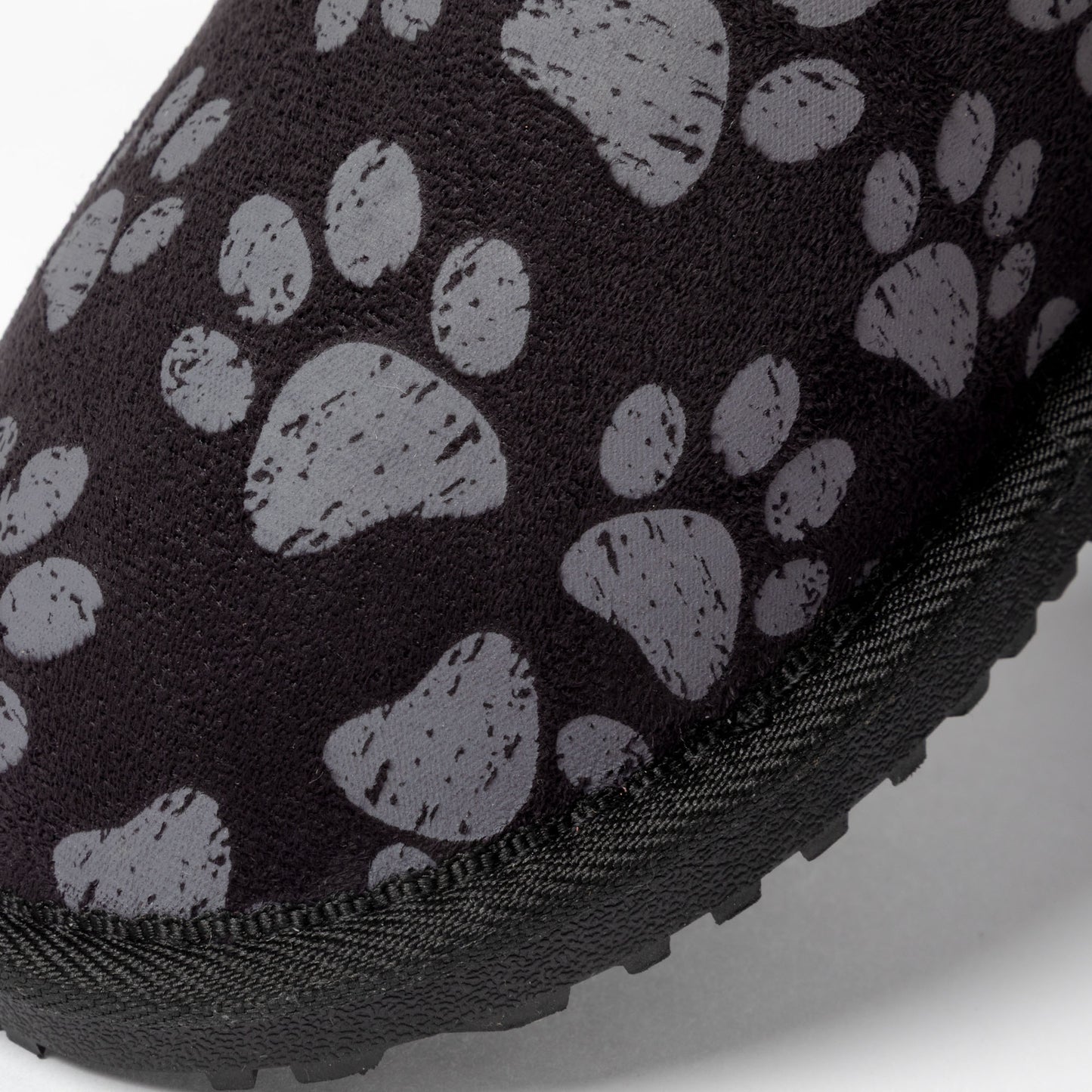 Close-up of a black shoe with gray paw print pattern on a white background