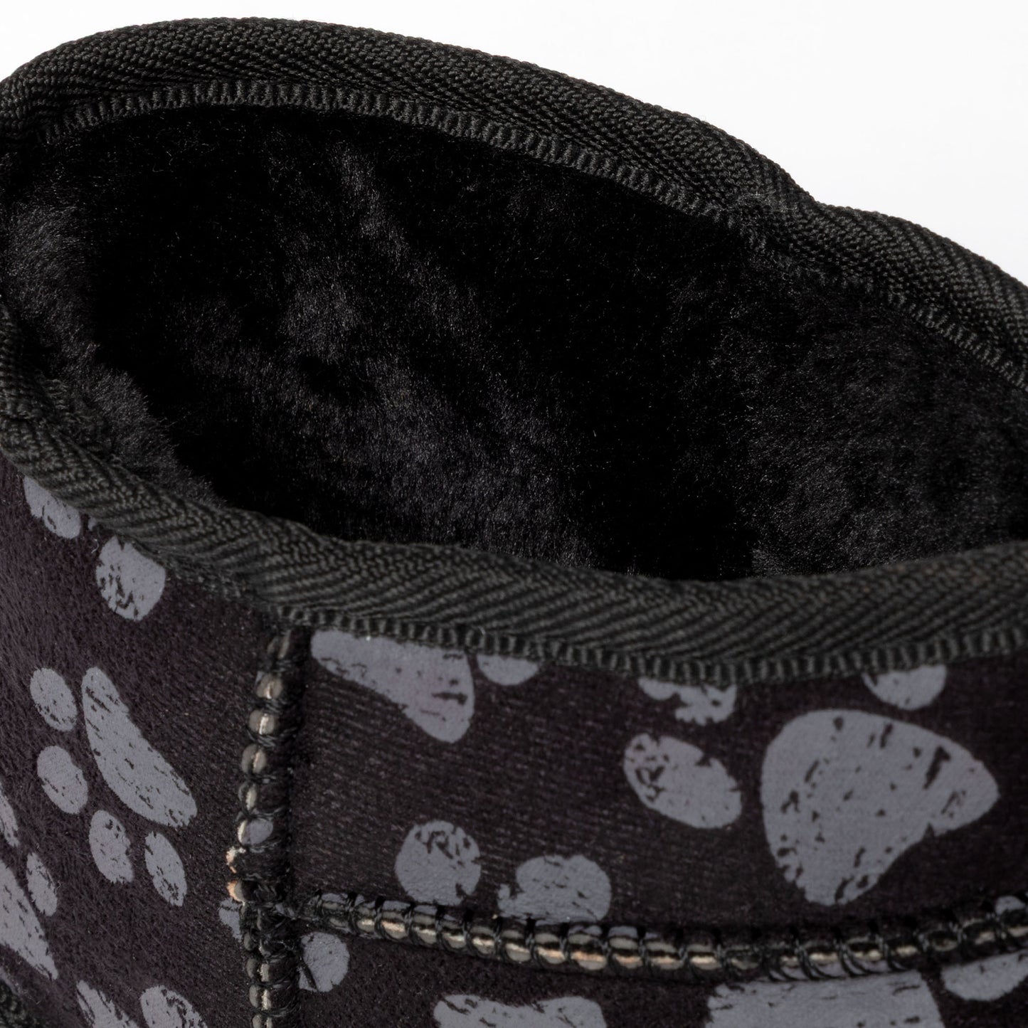 Close-up of a black slipper with paw print pattern and soft interior