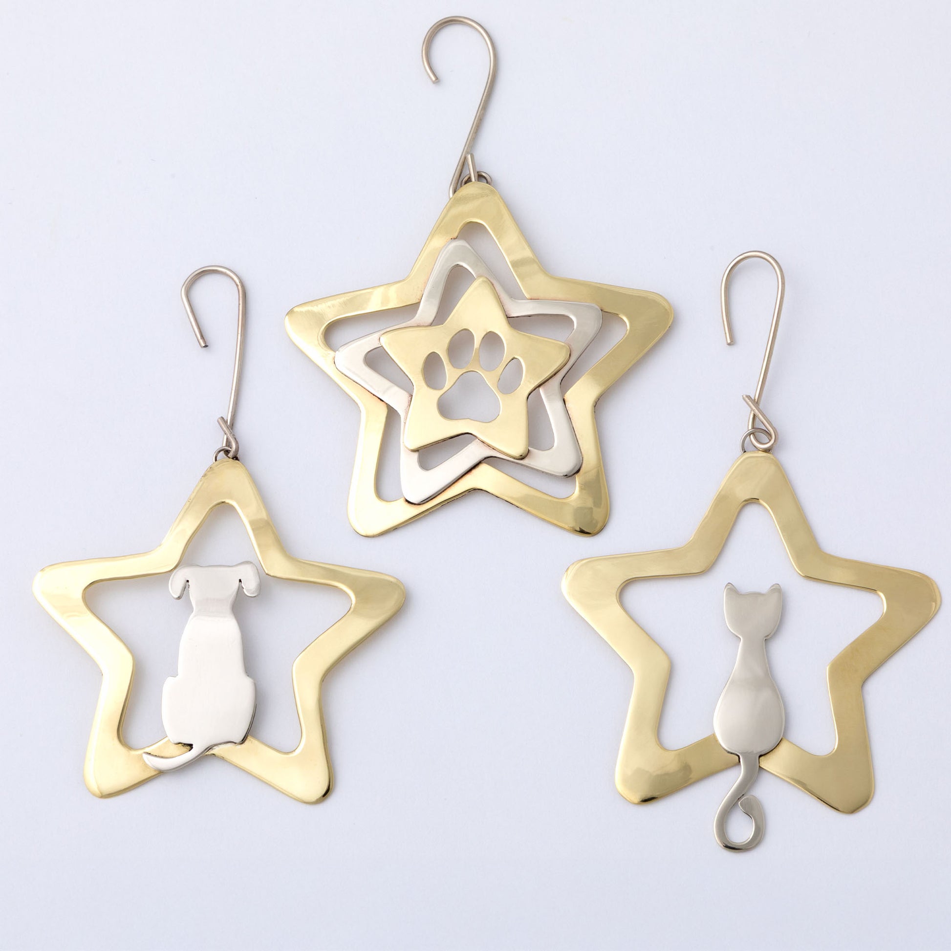 Star-shaped earrings with paw print, dog, and cat cutouts on a light gray background