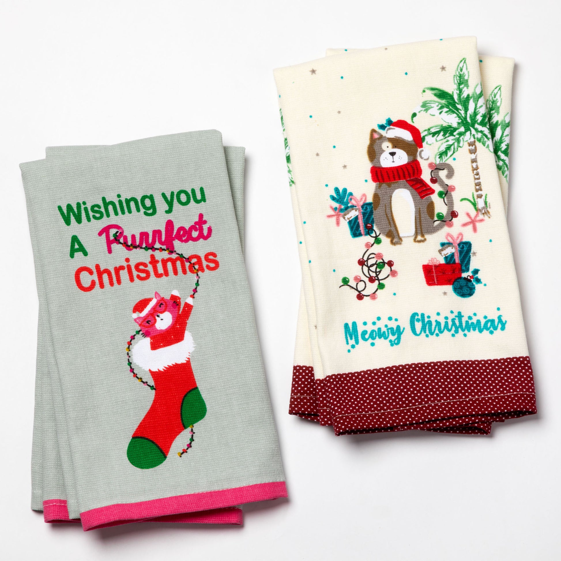 Two Christmas-themed kitchen towels with festive designs and text.