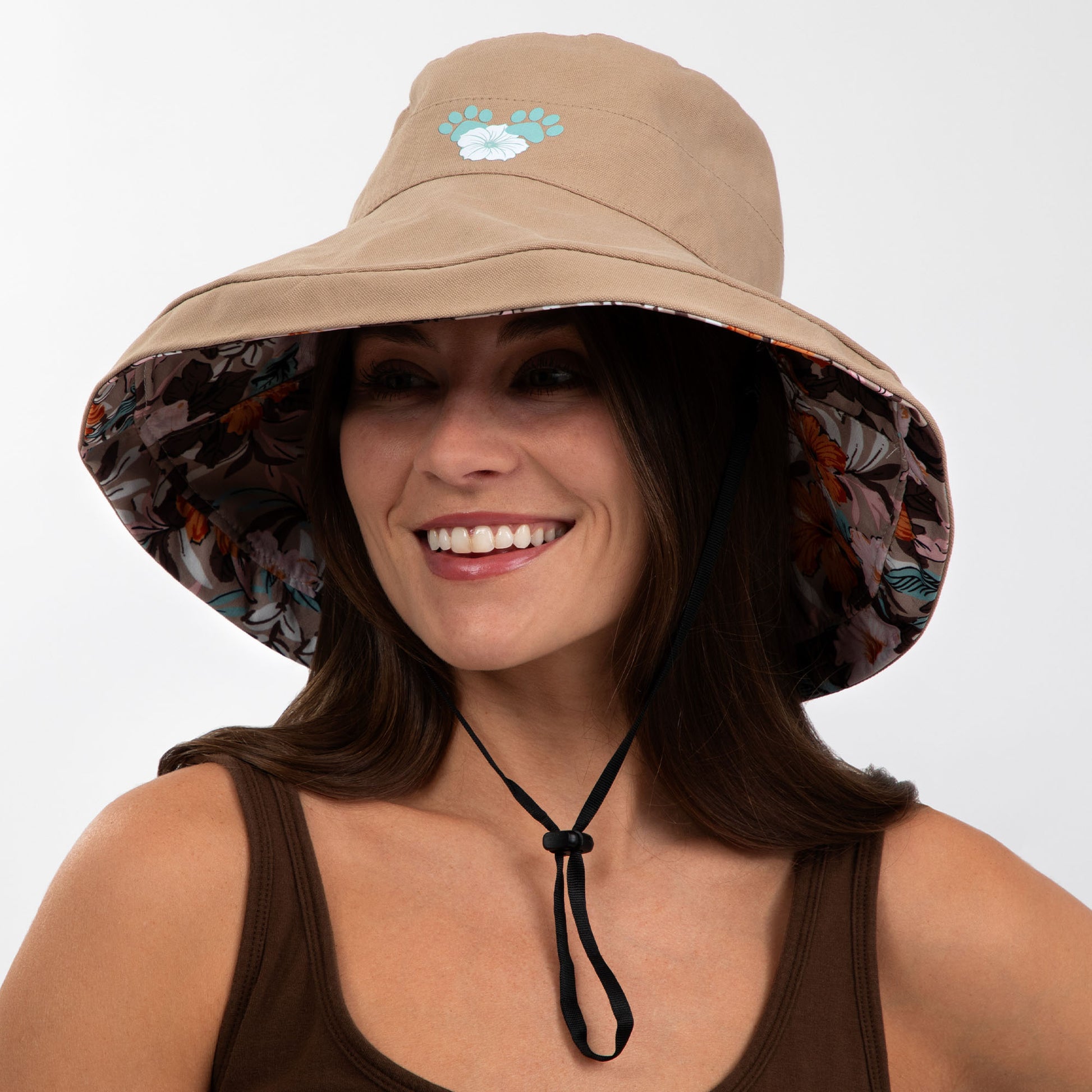 Woman wearing a beige bucket hat with floral interior on a white background