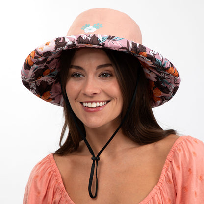 Woman wearing a floral-patterned sun hat on a white background