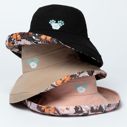 Three bucket hats with floral and solid designs stacked on a light gray background