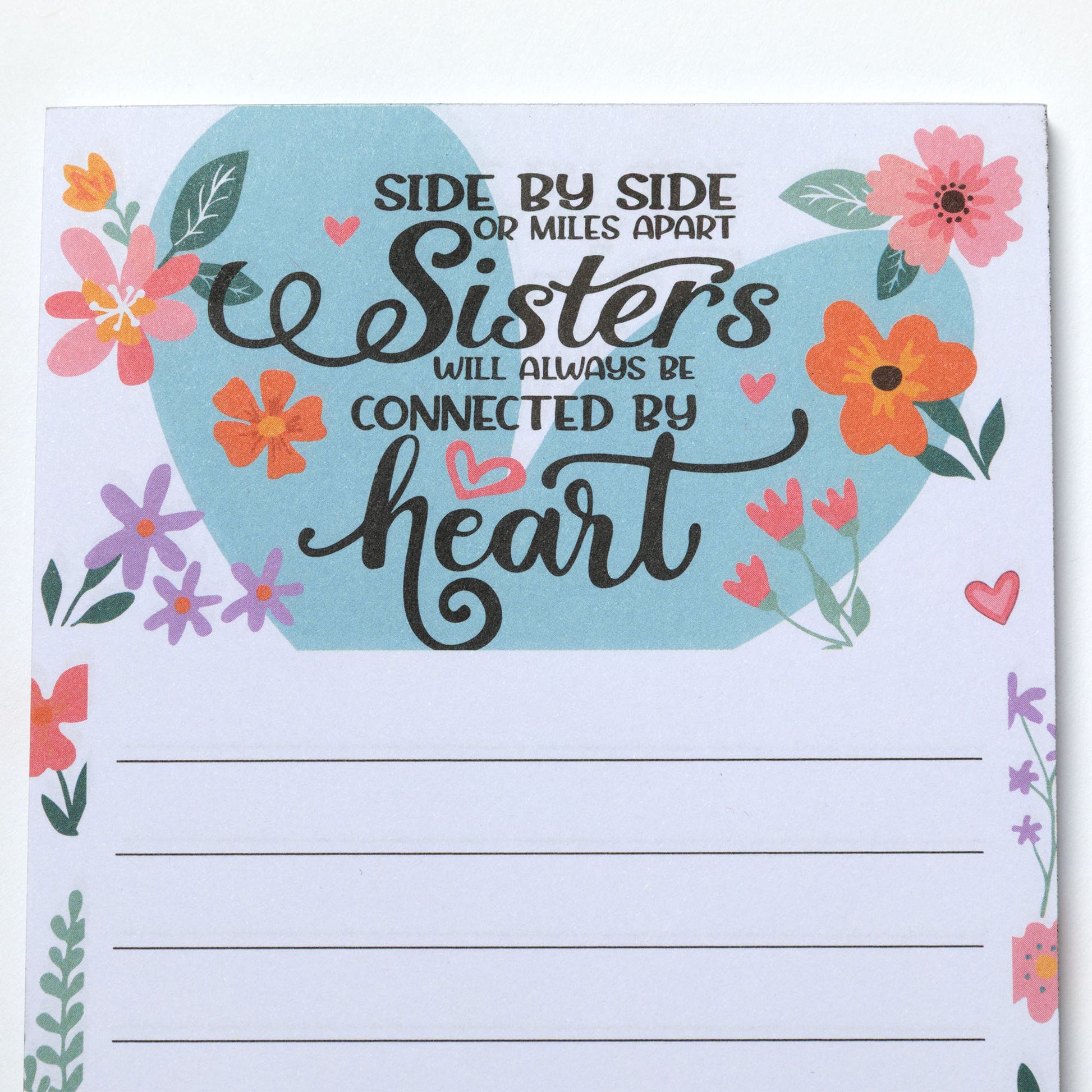 Notepad with floral design and motivational quote on a white background.