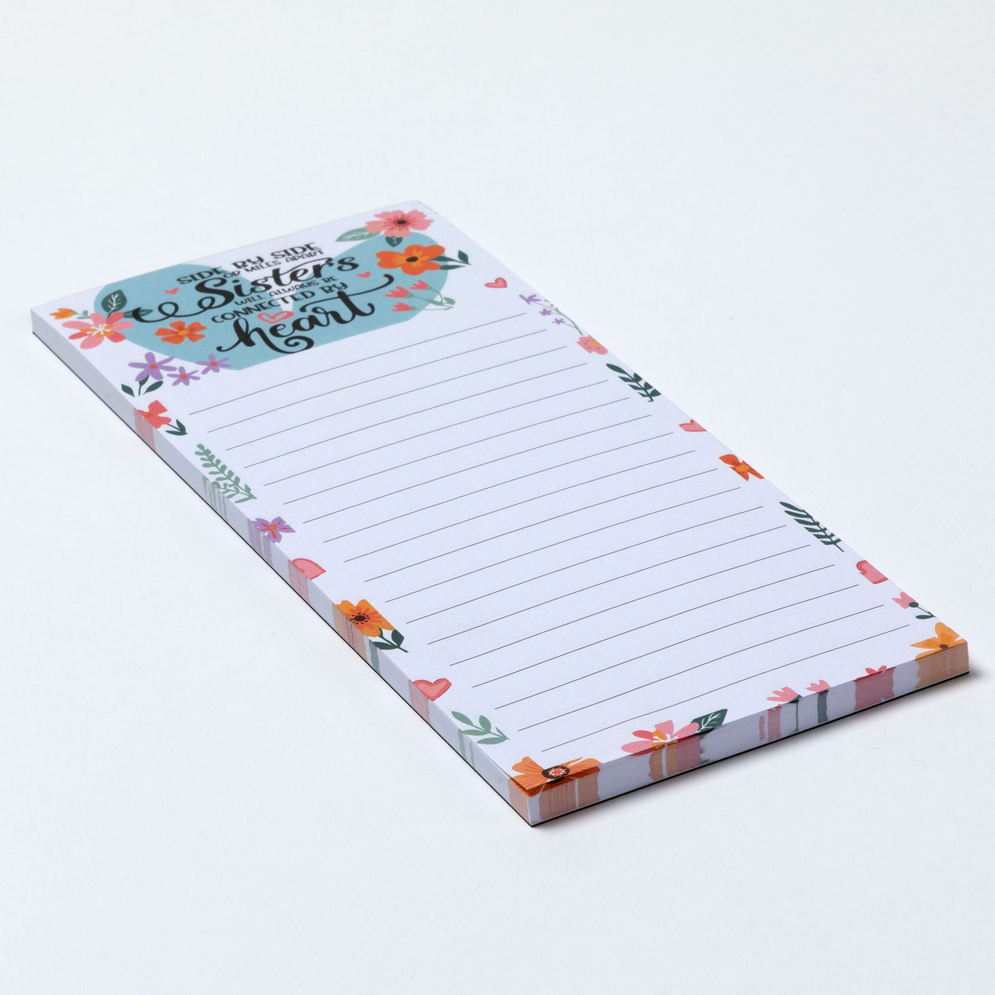 Notepad with floral design and inspirational message about sisterhood on a white background.