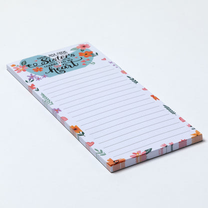 Notepad with floral design and inspirational message about sisterhood on a white background.