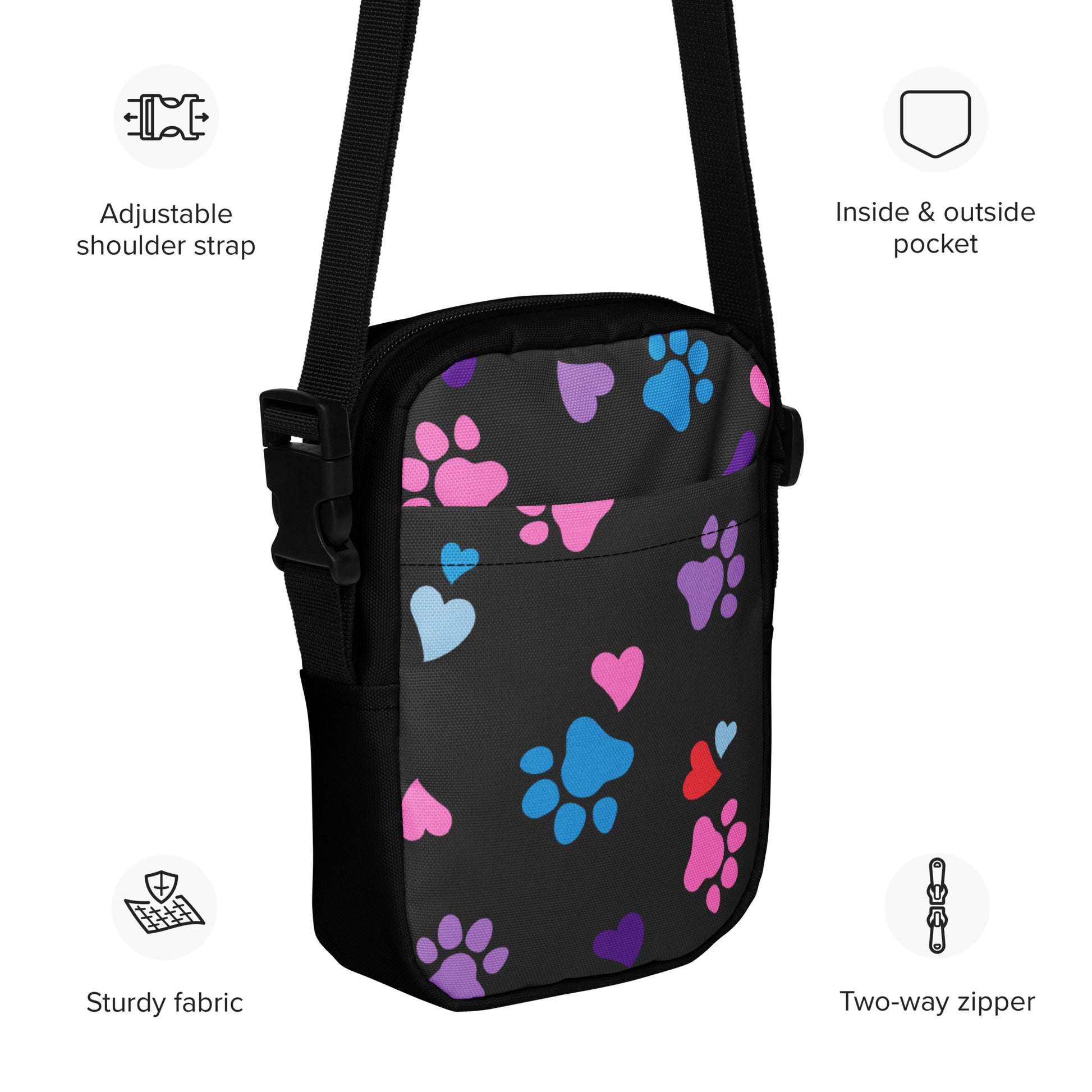 Black crossbody bag with colorful paw prints and heart designs, featuring text labels on a white background.
