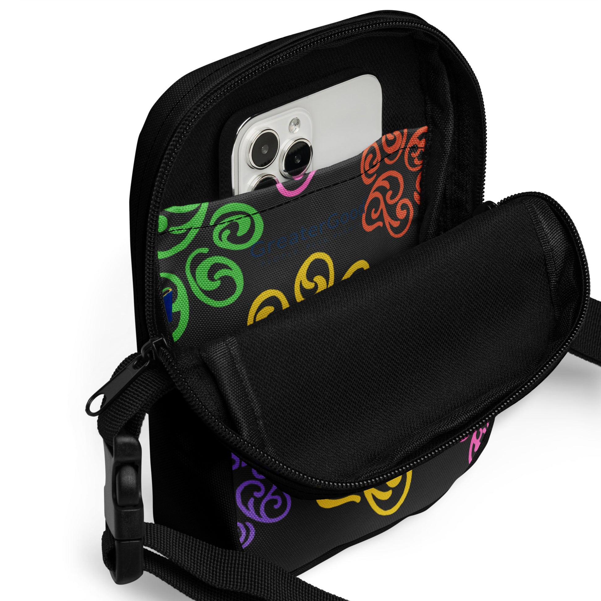 Close up of a pocket inside a Black crossbody bag with colorful patterns on a white background