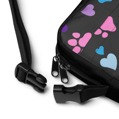 close up of a buckle on a Black bag with colorful heart patterns on a white background