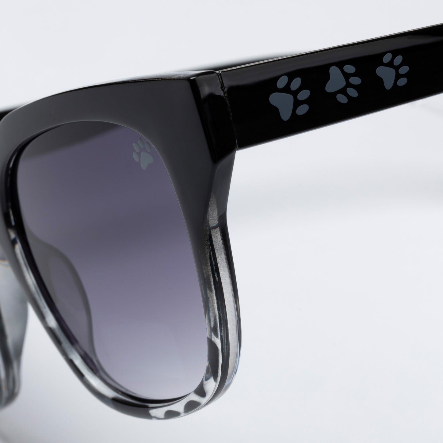 Black sunglasses with paw print design on arms against a light gray background