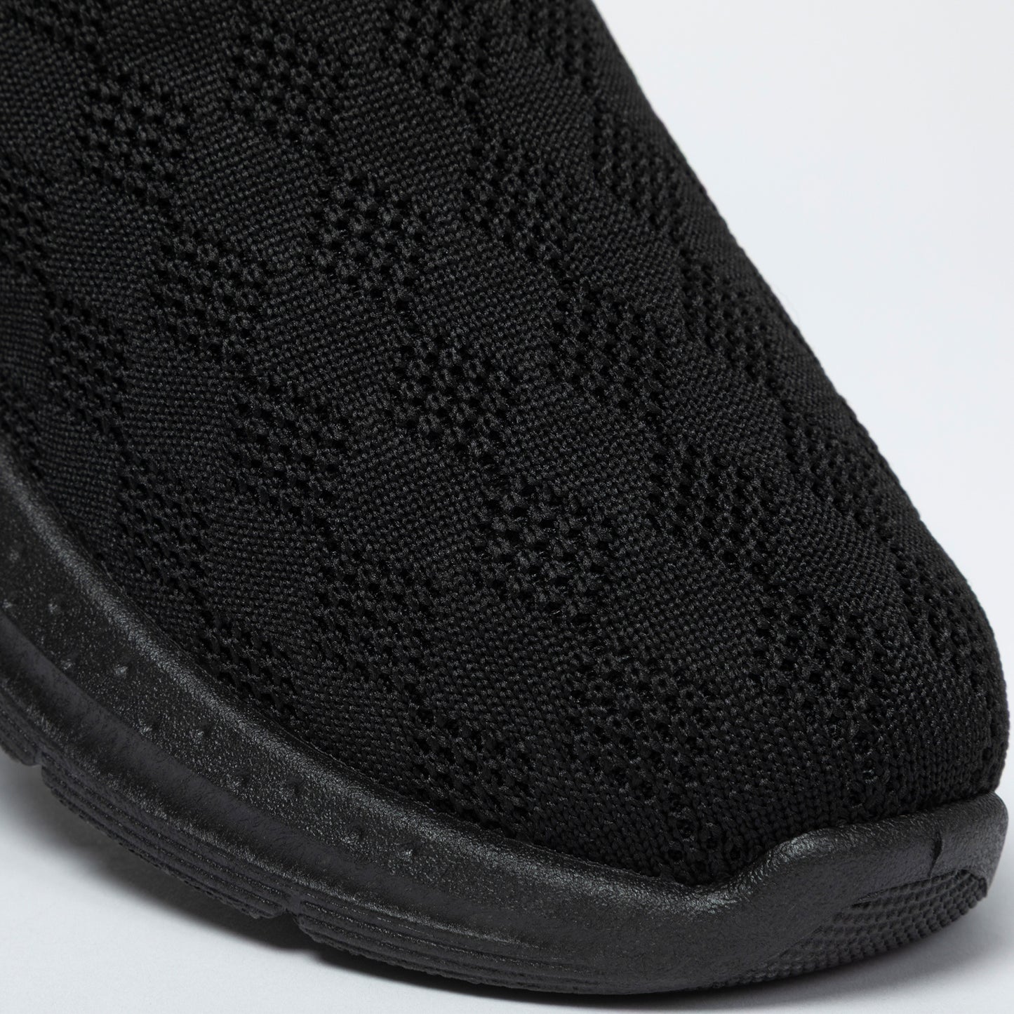 Close-up of a black slip-on clogs with textured knitted upper on a white background