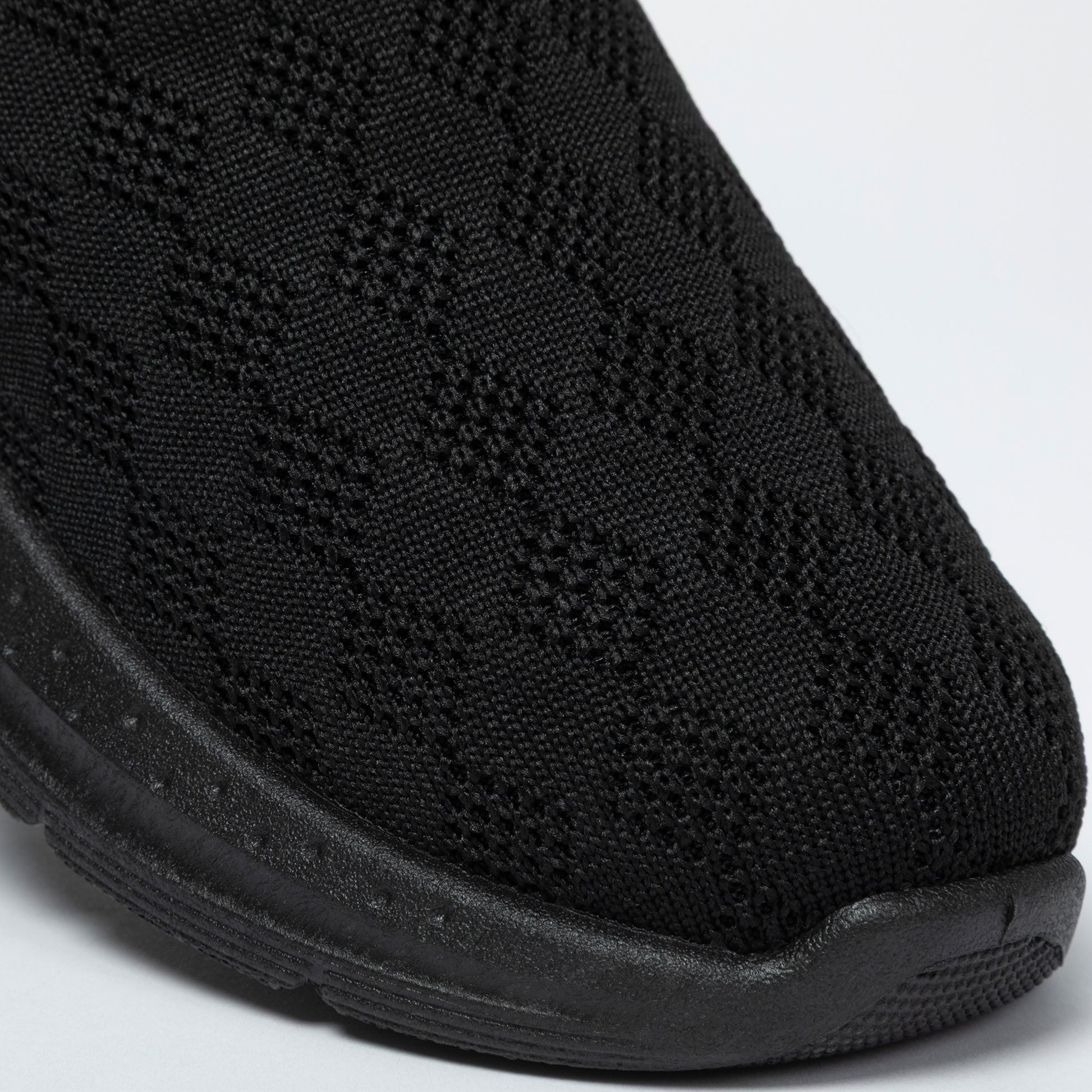 Close-up of a black slip-on clogs with textured knitted upper on a white background