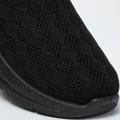 Close-up of a black slip-on clogs with textured knitted upper on a white background