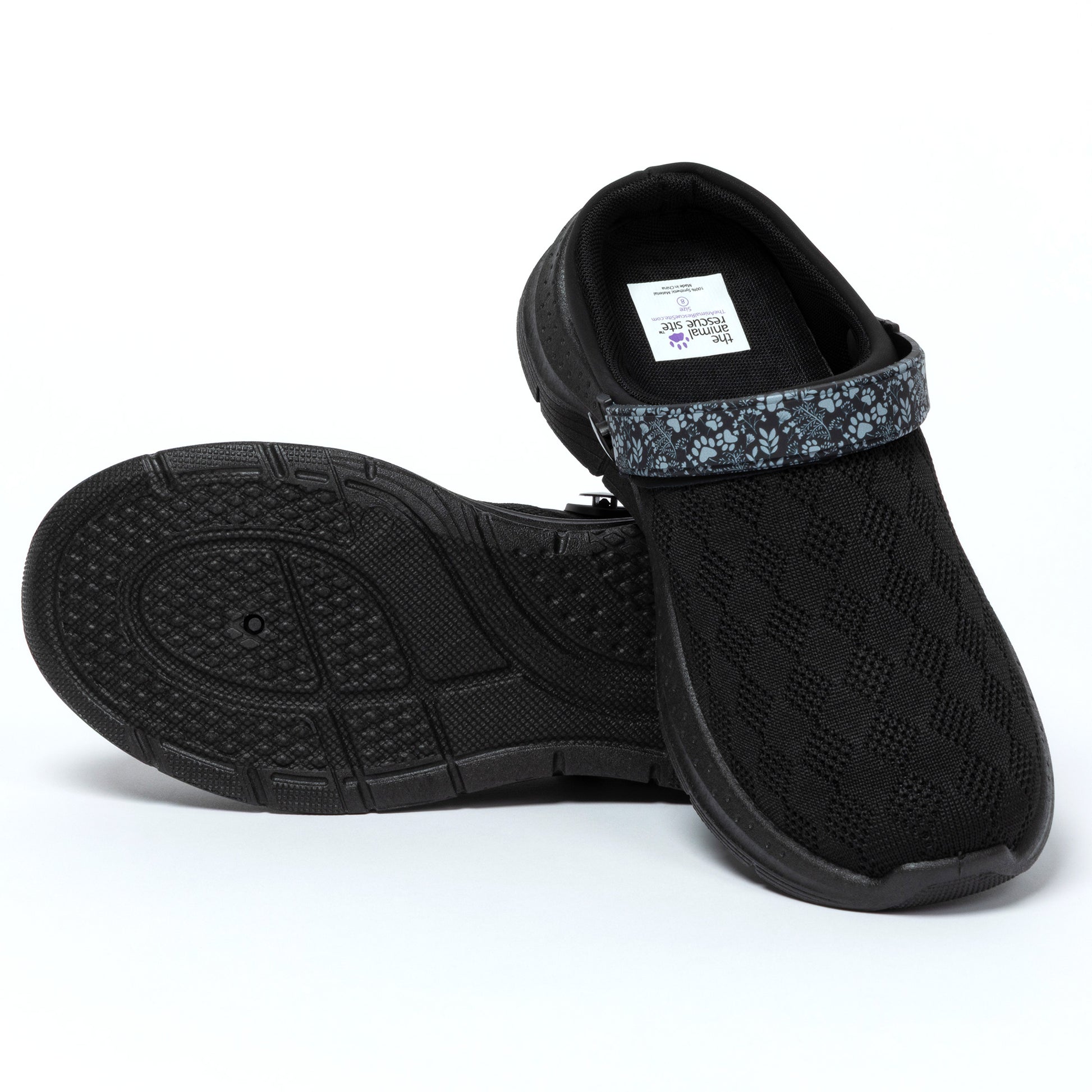 Black slip-on shoes with textured sole on a white background