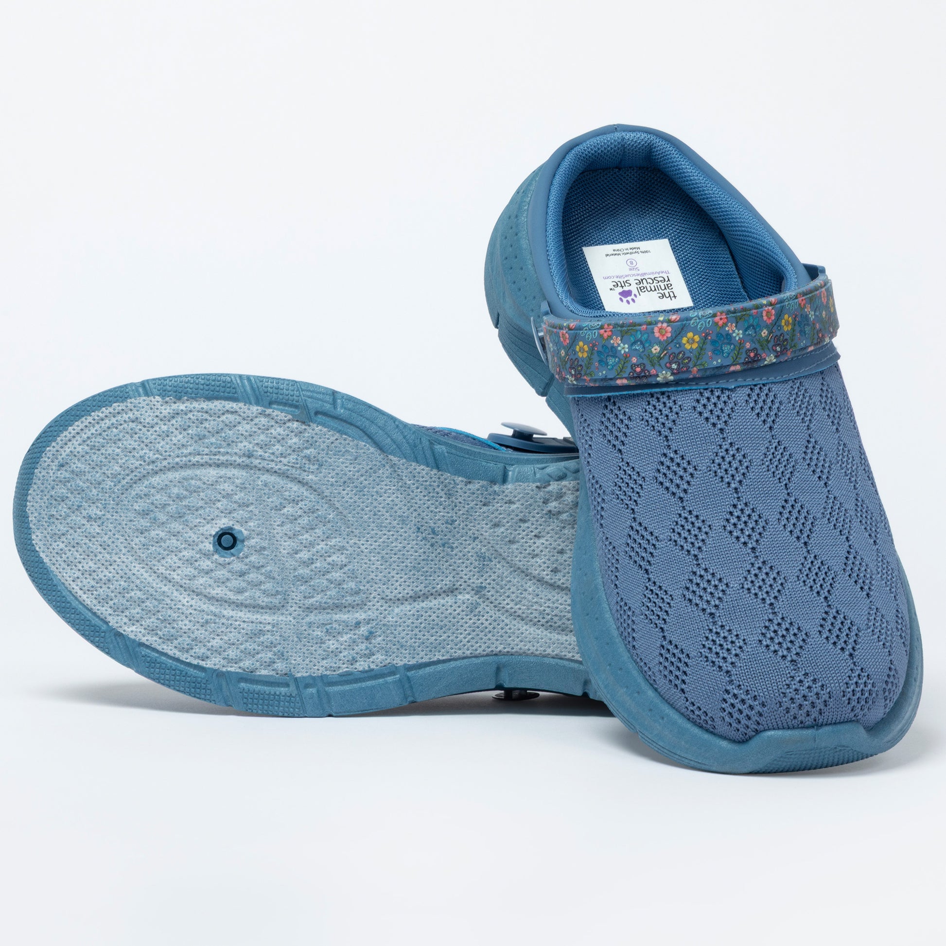 Blue clog shoes with a floral strap on a white background