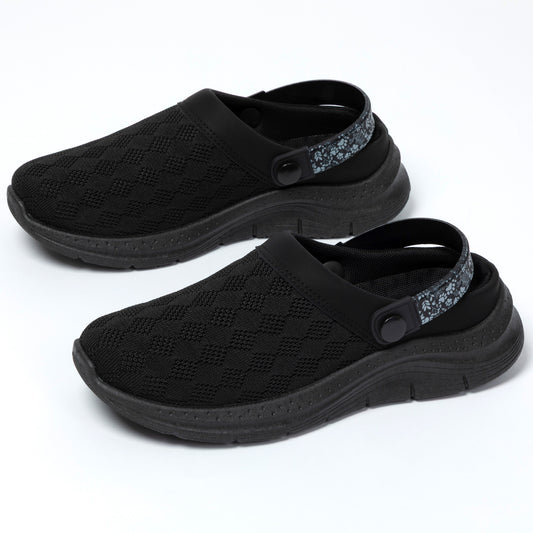 Black clogs with textured sole and floral strap on a white background