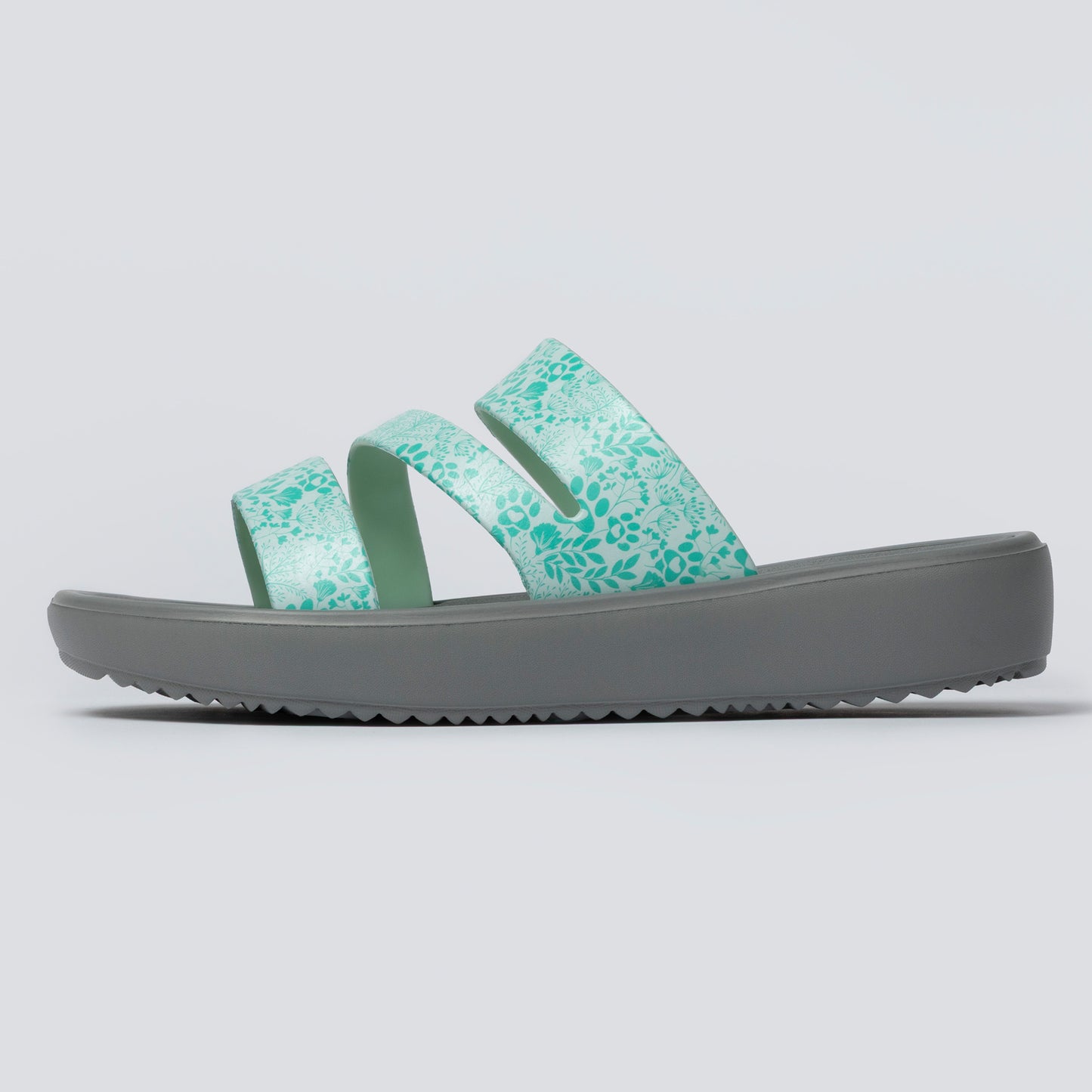 Green slide sandal with gray sole on a light gray background