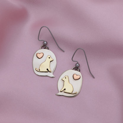 Pair of earrings with dog illustrations and heart symbols on a pink background