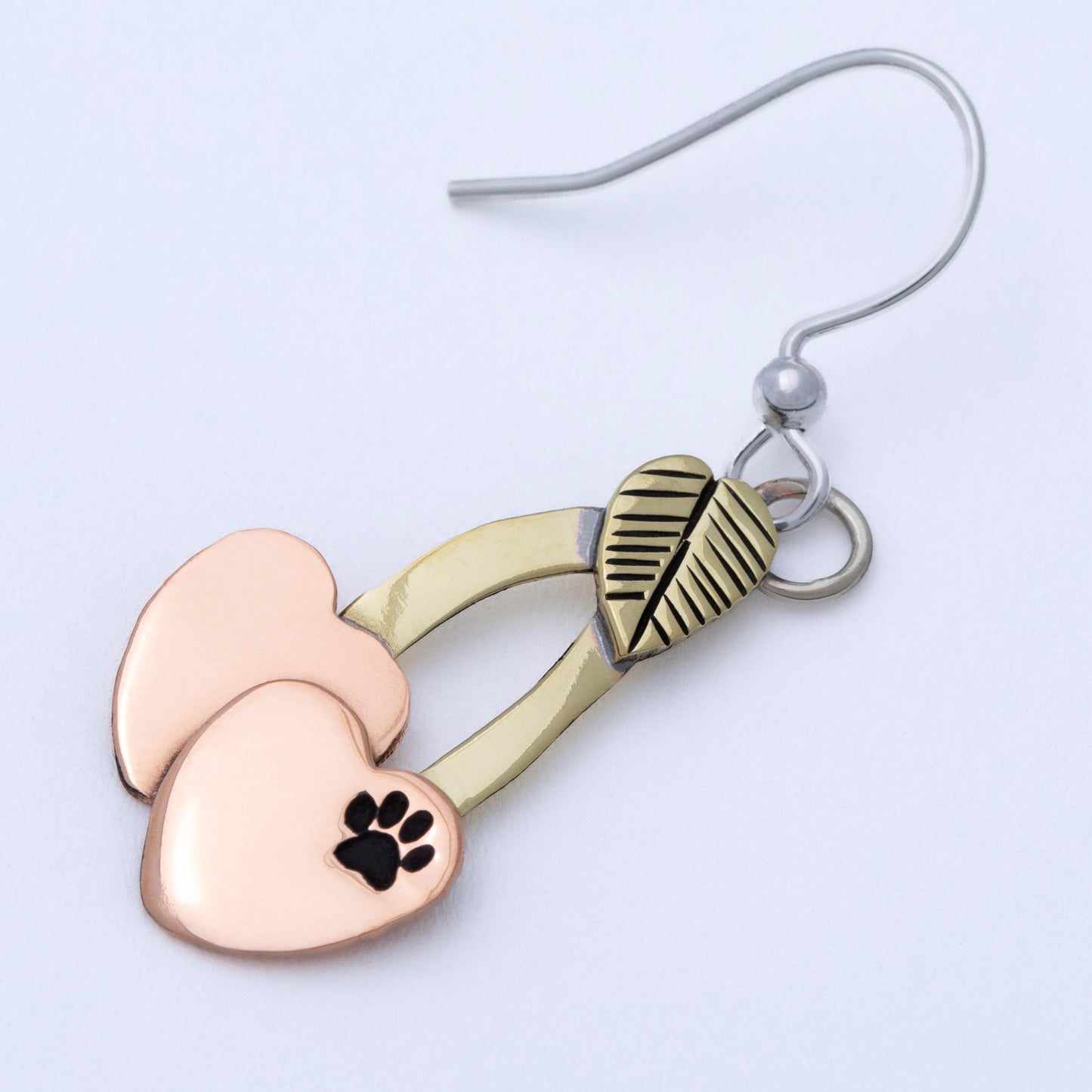Cherry shaped mixed metal earrings with a small paw print, on a white background.