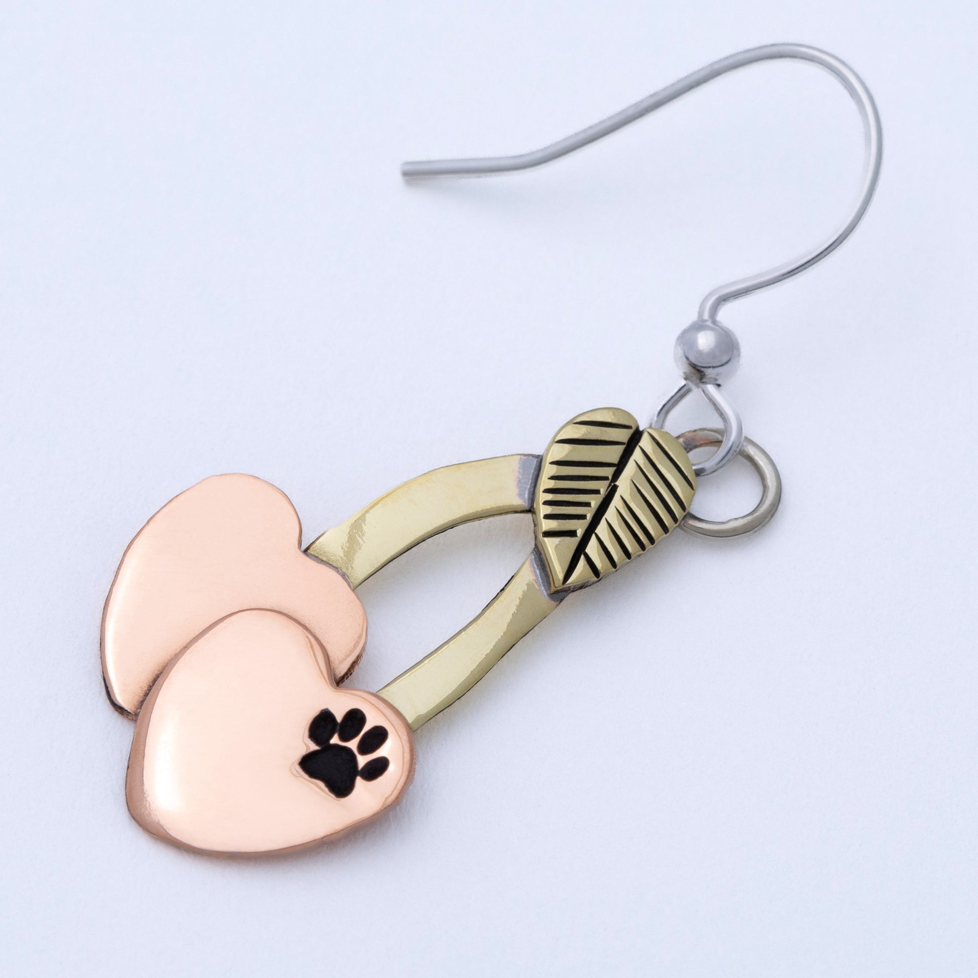 Cherry shaped mixed metal earrings with a small paw print, on a white background.