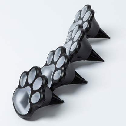 Black paw-shaped garden lights with spikes on a white background