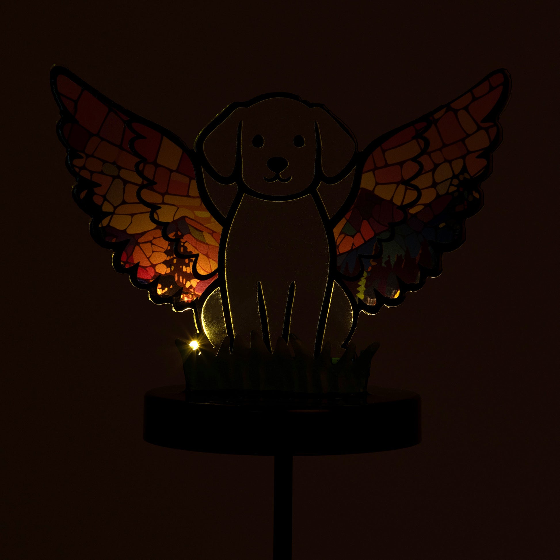 Glowing dog angel garden stake, shown on a white background, and in the dark with the light glowing.