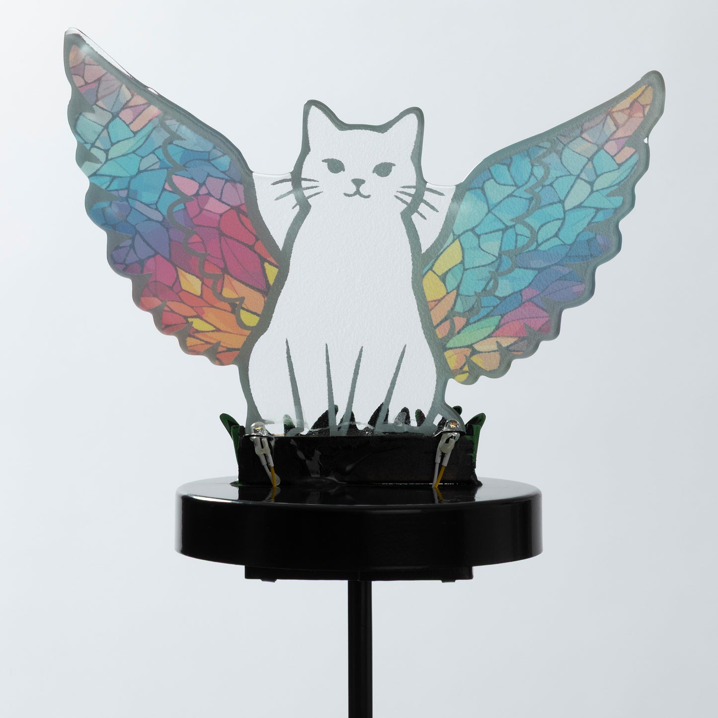 Cat silhouette with mosaic angel wings on a garden stake, against a white background.
