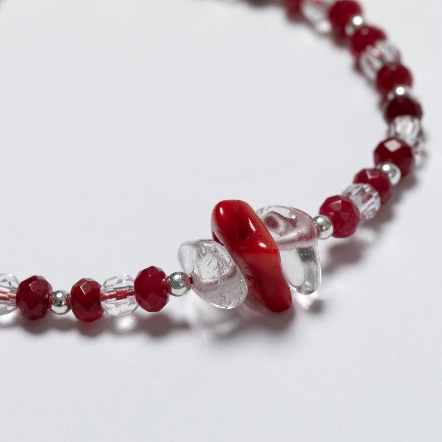 Beaded bracelet with red and clear beads on a white background