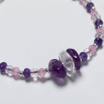 Necklace with purple, pink, and clear beads on a white background