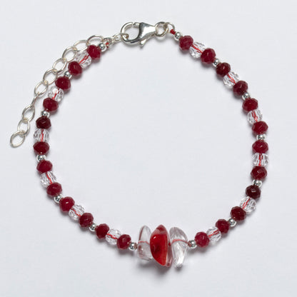 Bracelet with red and clear beads on a white background