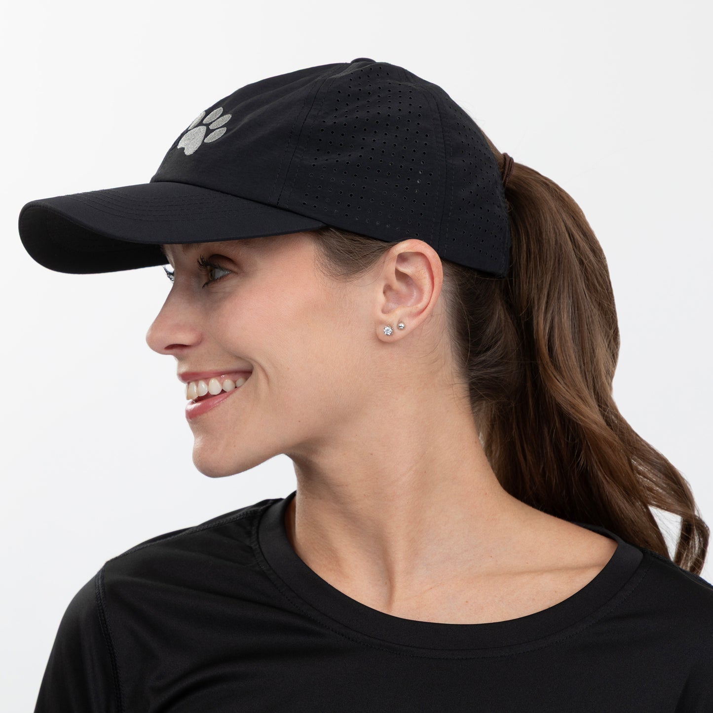 Woman wearing a black cap with a paw print design on a white background