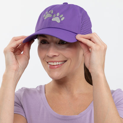 Woman wearing a purple cap with paw prints on a white background