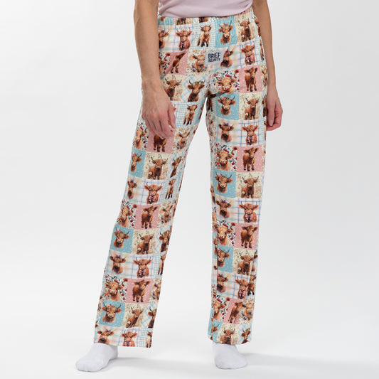 Pajama pants with cow pattern worn by a person on a white background