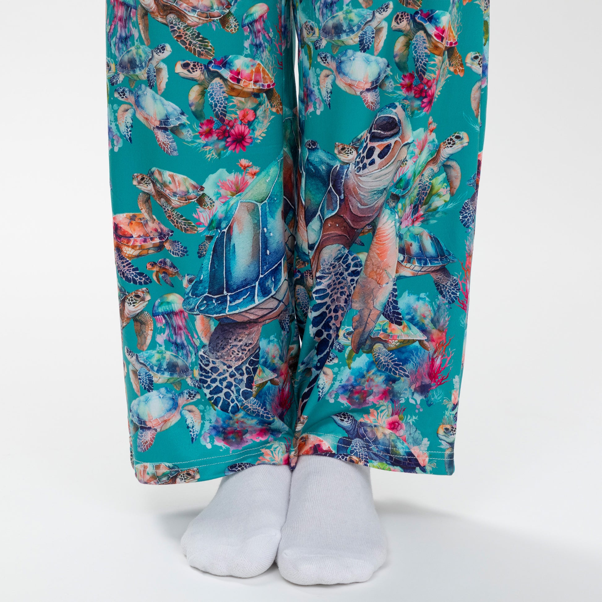 Colorful pants with sea turtle and floral pattern on a white background