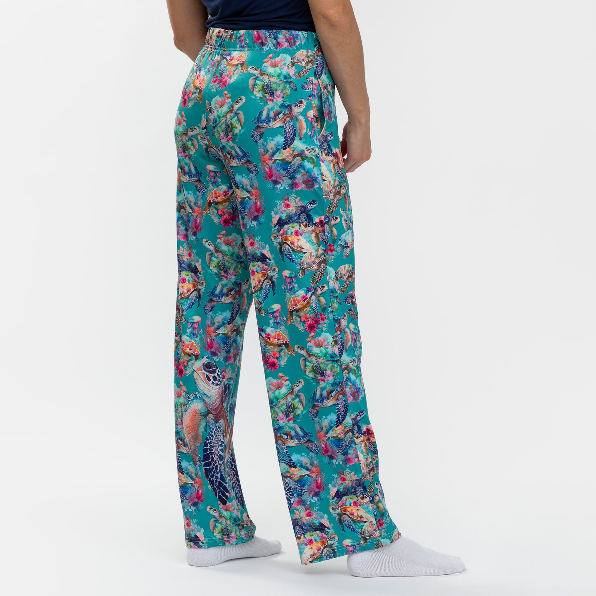 Colorful floral and turtle patterned pants on a white background