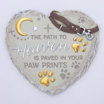 Heart-shaped plaque with 'The Path to Heaven is Paved in Your Paw Prints' text, gold paw prints, and a brown leather strap on a white background.