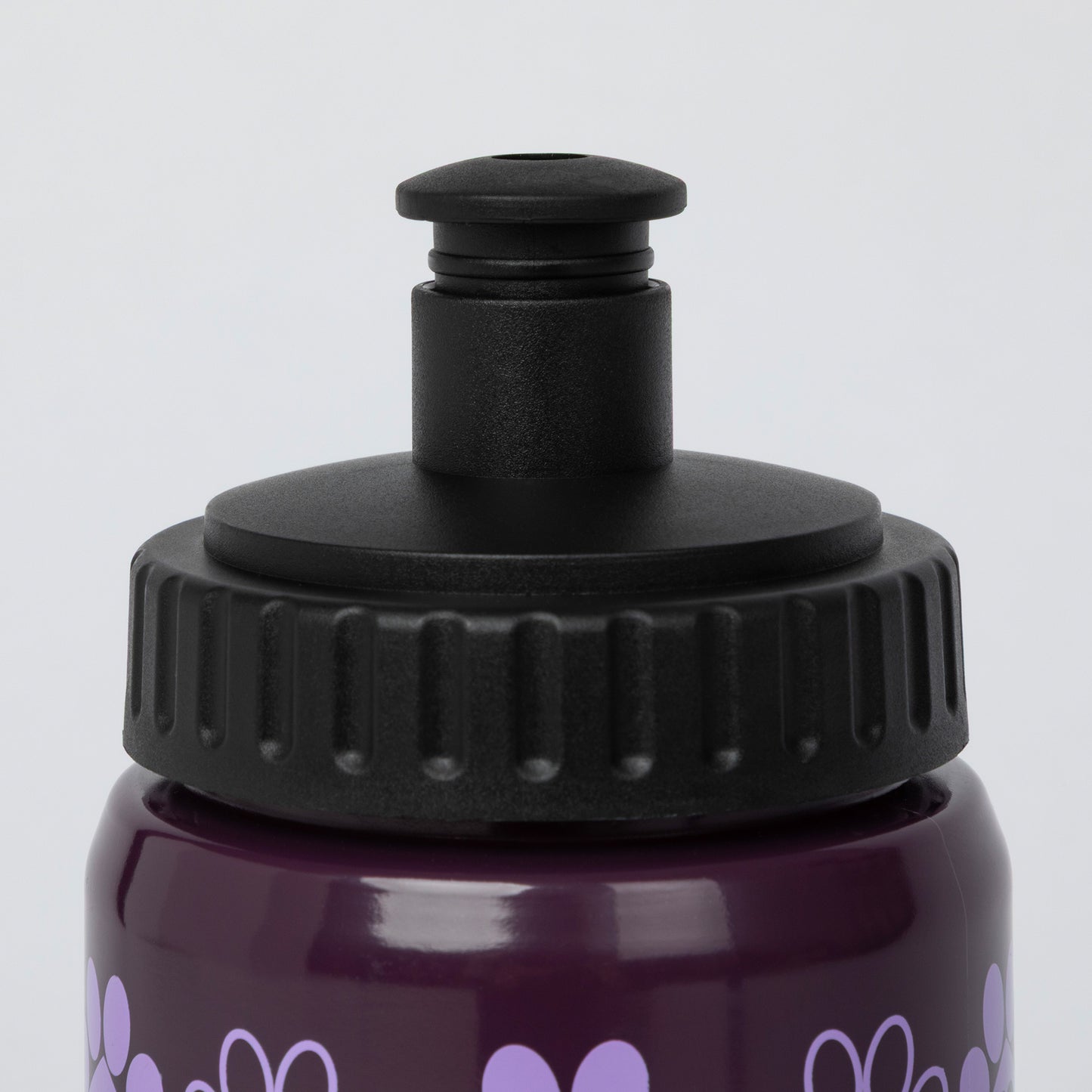Close-up of a dark purple water bottle with a black flip-top lid and light purple heart pattern on a light gray background.