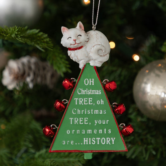 A Christmas ornament shaped like a white cat sitting on top of a green Christmas tree with red bells and the text 'OH Christmas TREE, oh Christmas TREE, your ornaments are.